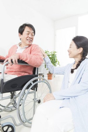 Téléchargez les photos : Asiatique femme avec homme en fauteuil roulant - en image libre de droit