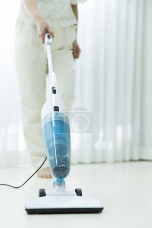 Photo for Woman cleaning the house with  vacuum cleaner. - Royalty Free Image