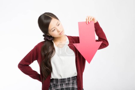 young asian girl with red arrow down on white background.
