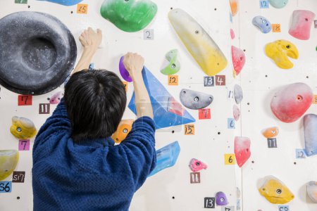 Téléchargez les photos : Man climbing on wall in gym - en image libre de droit