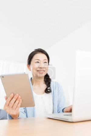 Foto de Mujer asiática usando portátil y tableta - Imagen libre de derechos