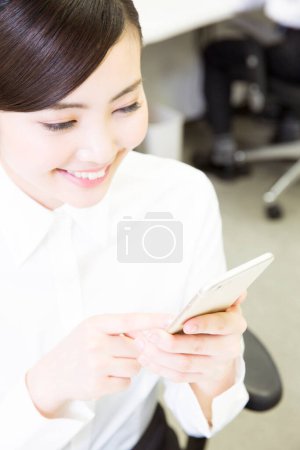 Photo for Young asian businesswoman  using  smartphone in office - Royalty Free Image
