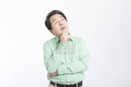 Foto de El hombre de negocios asiático pensando en el fondo blanco. - Imagen libre de derechos