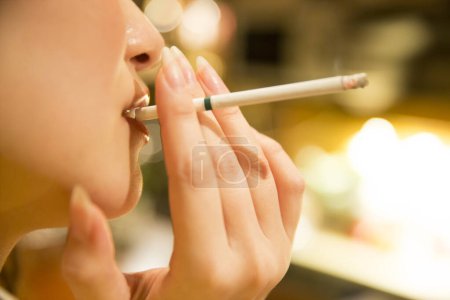 Foto de Primer plano asiático mujer fumar cigarrillo en café - Imagen libre de derechos