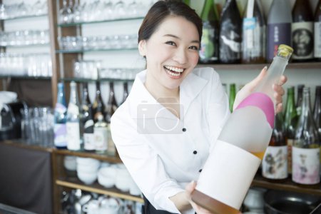Téléchargez les photos : Femme barista tenant bouteille de boisson - en image libre de droit