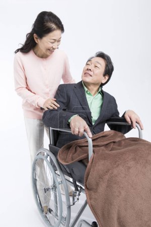 Foto de Feliz anciano en silla de ruedas y mujer sobre fondo blanco - Imagen libre de derechos