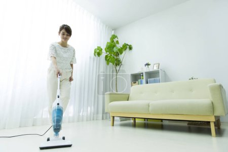 Photo for Woman cleaning her house with  vacuum cleaner - Royalty Free Image