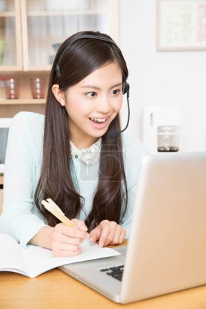 Téléchargez les photos : Portrait de femme asiatique avec casque ayant leçon en ligne sur ordinateur portable - en image libre de droit