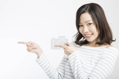 Téléchargez les photos : Belle femme japonaise gesticulant avec ses index isolés sur fond blanc - en image libre de droit