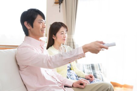 Téléchargez les photos : Jeune couple regarder la télévision - en image libre de droit