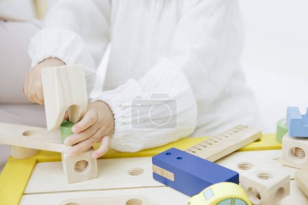 Téléchargez les photos : Enfant jouant avec des jouets en bois colorés - en image libre de droit
