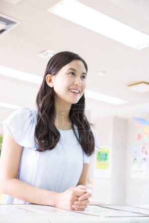 Téléchargez les photos : Jeune femme japonaise debout à la réception à l'école de conduite - en image libre de droit