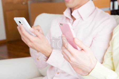 Téléchargez les photos : Couple de femme et homme avec des téléphones mobiles à la maison, gros plan - en image libre de droit