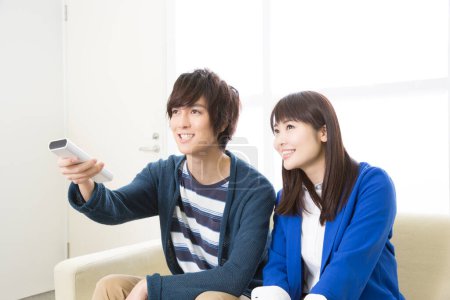 Téléchargez les photos : Couple avec télécommande regarder la télévision - en image libre de droit