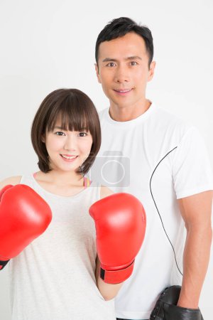Photo for Portrait of young japanese woman boxer with coach training together - Royalty Free Image