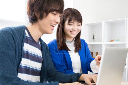 Foto de Asiático joven hombre y mujer usando laptop - Imagen libre de derechos
