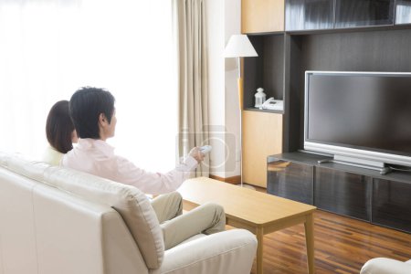Téléchargez les photos : Femme et homme regardant la télévision à la maison - en image libre de droit