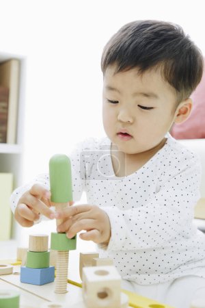 Foto de Cerrar hasta poco asiático chica jugando con madera juguetes - Imagen libre de derechos