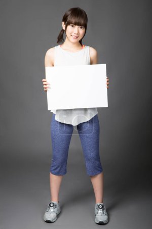 Photo for Young japanese woman holding a white blank sign - Royalty Free Image