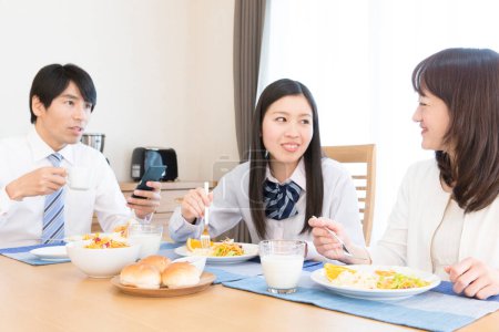 Téléchargez les photos : Famille japonaise de trois personnes déjeunant ensemble dans la cuisine - en image libre de droit