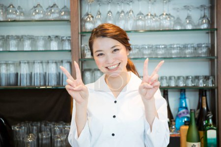 Photo for Smiling female waitress making ok sign - Royalty Free Image
