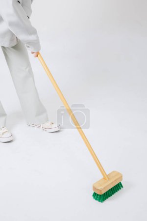 Photo for Asian woman mopping the floor on a gray background - Royalty Free Image