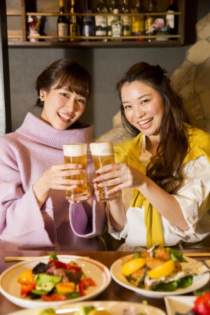 Téléchargez les photos : Jeune femme et son ami boire de la bière - en image libre de droit