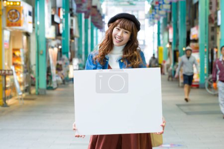 Foto de Chica asiática con tabla blanca en la ciudad - Imagen libre de derechos