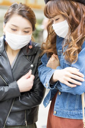 Foto de Mujeres jóvenes con máscaras médicas en la calle - Imagen libre de derechos