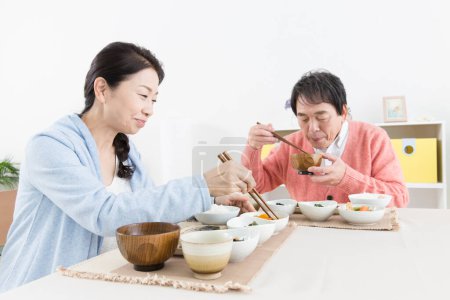 Photo for Senior asian couple having meal in kitchen - Royalty Free Image