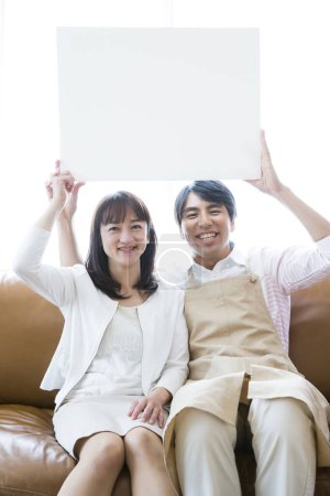 Photo for Young asian family holding blank white paper - Royalty Free Image