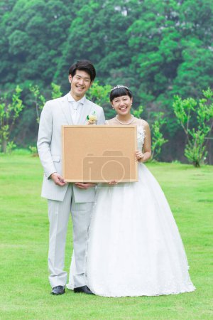 jeune asiatique mariage couple tenant vide signe dans parc 