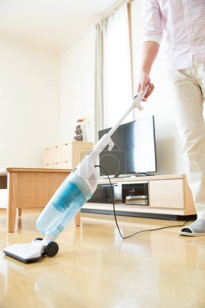 Photo for Young man with vacuum cleaner at home - Royalty Free Image