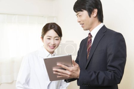 Téléchargez les photos : Homme d'affaires et médecin utilisant la tablette - en image libre de droit