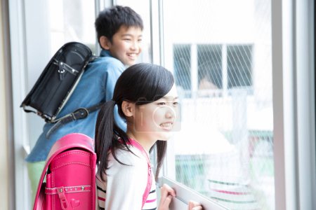 Foto de Estudiantes asiáticos en uniforme escolar con mochilas - Imagen libre de derechos