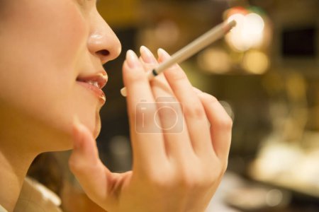 Foto de Primer plano asiático mujer fumar cigarrillo en café - Imagen libre de derechos