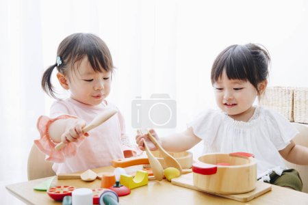 Nahaufnahme von niedlichen japanischen Mädchen, die zu Hause mit Spielzeug spielen 
