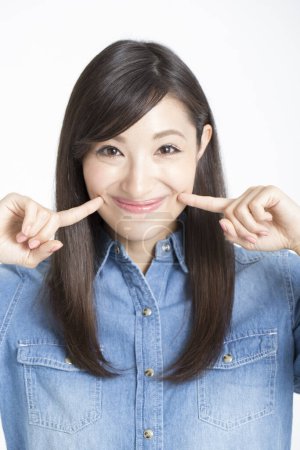 Photo for Young asian woman touching her face with fingers - Royalty Free Image