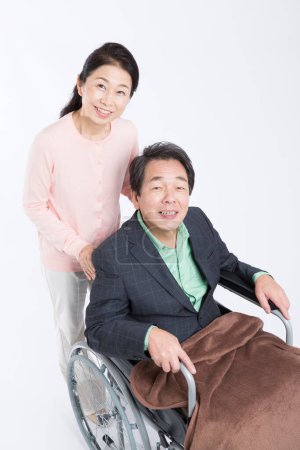 Photo for Asian senior man in Wheelchair and his mature wife - Royalty Free Image
