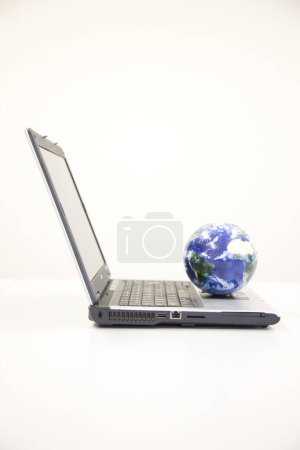 Photo for Globe with computer laptop on white background - Royalty Free Image