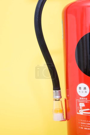 Photo for Fire extinguisher on yellow background, close up - Royalty Free Image