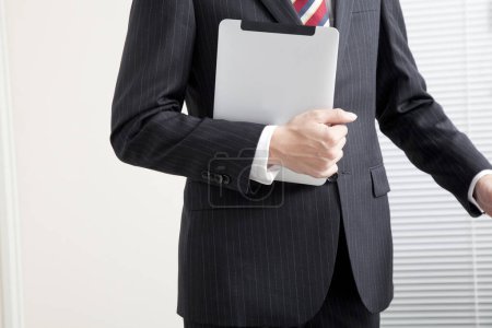 Photo for Business man holding a tablet in office - Royalty Free Image