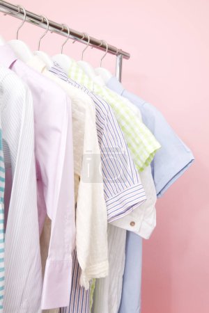 Photo for Colorful clothes on hangers against color background - Royalty Free Image