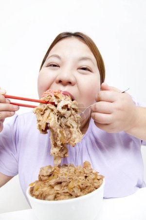 Photo for Overweight Asian woman eating meat. studio portrait - Royalty Free Image