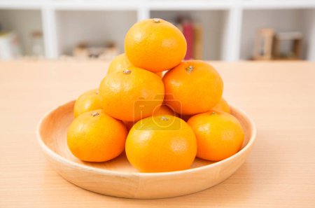 Foto de Mandarinas maduras en un plato sobre la mesa - Imagen libre de derechos