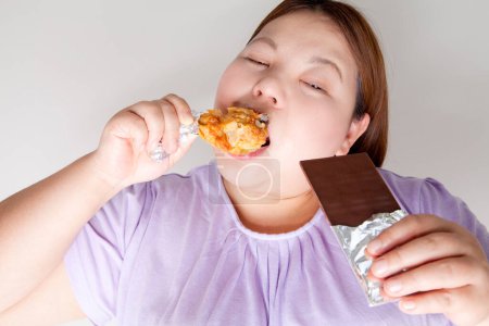 Photo for Close up overweight woman eating unhealthy food - Royalty Free Image
