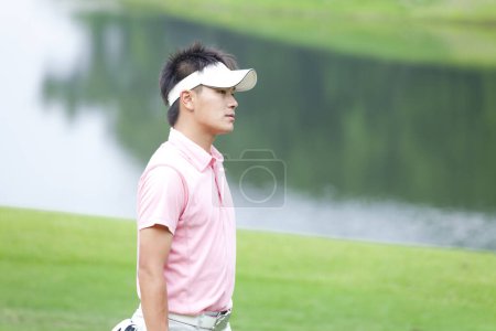 Téléchargez les photos : Jeune asiatique homme jouer golf - en image libre de droit