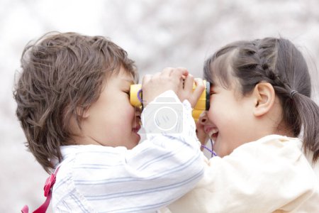 Téléchargez les photos : Asiatique petite fille et garçon avoir amusant dans printemps parc - en image libre de droit