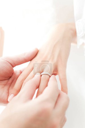 Téléchargez les photos : Une personne qui met une alliance sur le doigt d'une personne - en image libre de droit