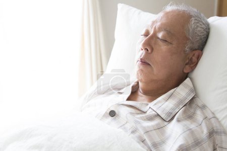Téléchargez les photos : Homme âgé dormant sur le lit - en image libre de droit